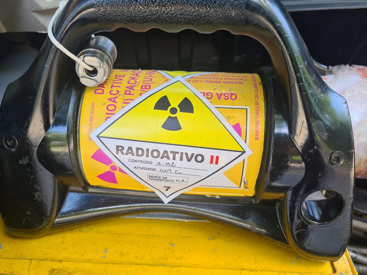 Irradiador gama (projetor de fonte) com rótulo de material radioativo, equipamento usado na gamagrafia industrial